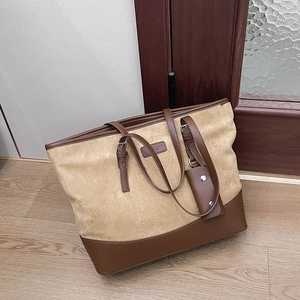 Detail of contrast-color tote bag featuring brown leather and beige suede textures