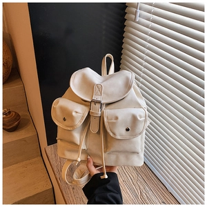 Detail of off-white travel backpack featuring silver metal buckles and flap pockets