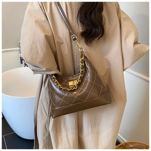 Détail du sac bandoulière matelassé marron avec chaîne dorée et fermoir pivotant