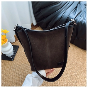 Gros plan du sac seau léopard avec texture en daim et bandoulière en cuir noir chic