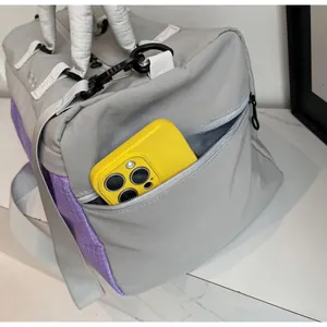 Detail of the side zipper pocket on a waterproof travel bag showing phone storage capacity