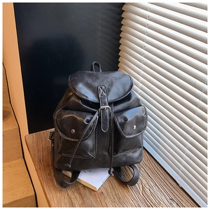 Detail view of American vintage backpack featuring buckle pockets and white stitching