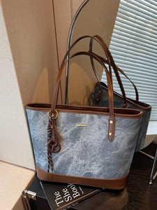 Blue marble texture tote bag with brown leather trim and metal tag for daily commute