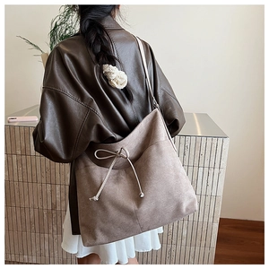 Detail shot of a vintage light brown tote bag with decorative bow and textured surface