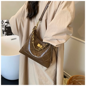 Gros plan du sac matelassé marron rétro en cuir brillant avec bandoulière chaîne dorée