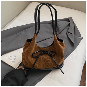 Detailed close-up of leopard print velvet tote with black leather trim and bow tie