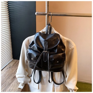 Detailed view of the black retro leather backpack with contrast stitching and metal studs