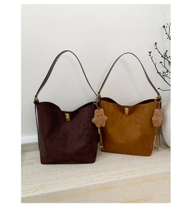 Macro shot of two vintage matte leather tote bags with gold buckles and star charms