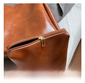 Detail shot of the golden metal zipper and brown textured leather on this vintage bucket bag