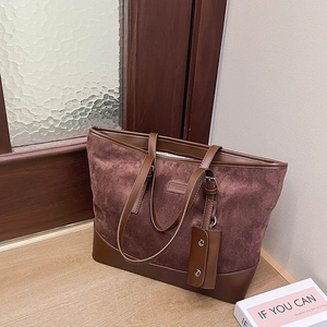 Detail of vintage tote bag with reddish-brown faux suede and dark leather trim