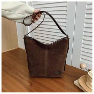Vue détaillée du sac Hobo marron foncé en daim brossé avec plaque logo métallique