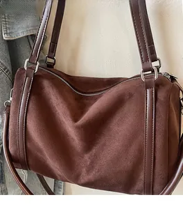Close-up of deep brown suede texture and silver hardware on this stylish tote bag