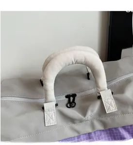 Close-up of reinforced handles and double zipper on large grey travel storage bag