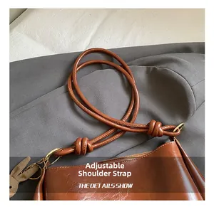 Detail of brown faux leather tote with adjustable knot strap and cute rabbit pendant