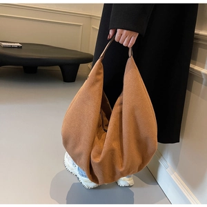 Détail d'un grand sac hobo en daim marron avec un design minimaliste et souple