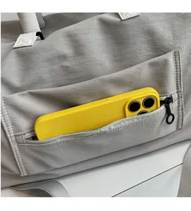 Detail of waterproof grey travel bag showing side zipper pocket holding a smartphone