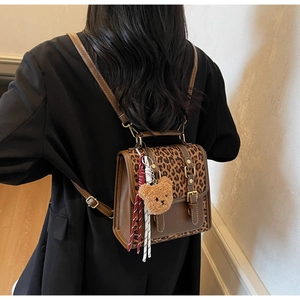 Detailed back view of a retro leopard print mini backpack with a cute plush bear charm
