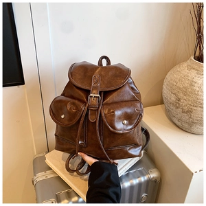 Close-up of vintage brown leather backpack with flap magnetic pockets and drawstring closure