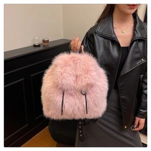 Close-up of pink faux fur backpack on a model wearing a black leather jacket