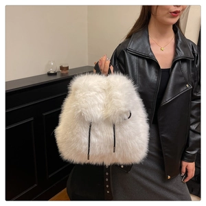Detail view of a fluffy white faux fur backpack with black straps for autumn and winter