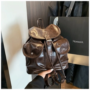 Detailed shot of dark brown vintage backpack with retro buckles and dual front pockets
