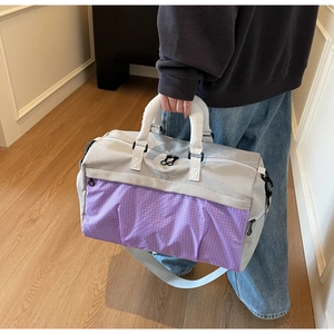 Detailed shot of large grey and purple travel bag with reinforced handles and brand logo