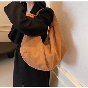 Vue détaillée du sac à bandoulière en daim marron avec design plissé en demi-lune