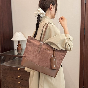 Detail view of brown vintage tote bag with suede texture and small hanging coin pouch