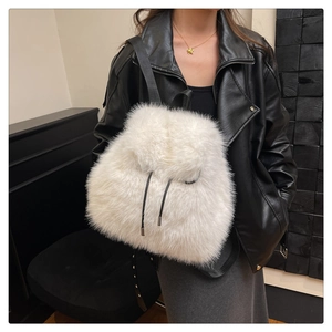 Detail of white faux fur backpack featuring a drawstring closure and soft fluffy texture