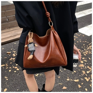 Brown vintage leather hobo bag with cute rabbit charm detail and knotted shoulder strap