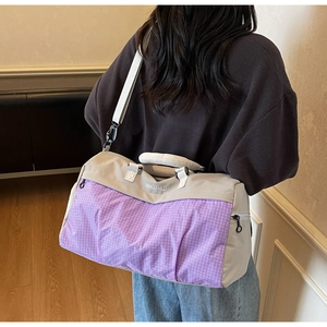 Detail of waterproof travel bag with grey and purple check pattern and MINGDAILD logo