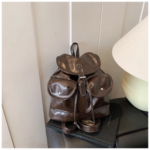 Detail of vintage dark brown faux leather backpack with drawstring and silver hardware