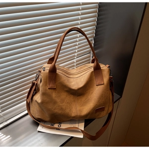 Detailed close-up of large camel canvas tote bag with adjustable strap and textured finish