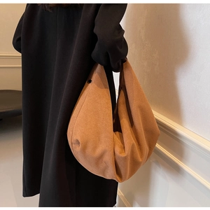 Détail du grand sac cabas en cuir givré caramel avec bouton-pression noir sur le côté