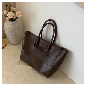Detailed view of the dark brown retro tote bag featuring a hollow handle and fine strap
