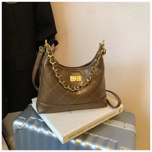 Détail du sac matelassé marron foncé avec chaîne dorée et fermoir rotatif