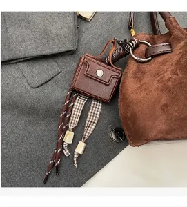 Detalle de colgante de cuero marrón retro con correas tejidas decorativas y hebilla de metal