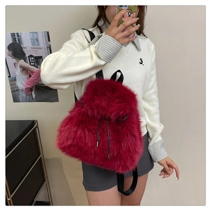 Mirror selfie showing the side view of the red plush backpack with drawstring closure