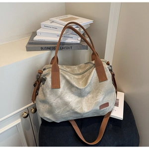 Detailed macro view of the light gray canvas tote bag featuring premium metal zip fasteners