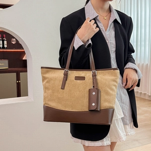 Detail of vintage beige suede tote bag with brown leather straps and small hanging pouch