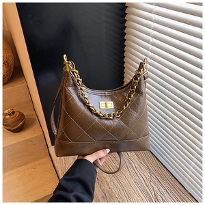 Détail du sac en similicuir matelassé marron avec chaîne dorée et fermoir pivotant