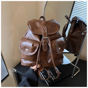 Detail view of dark brown retro leather backpack with white contrast stitching and pockets