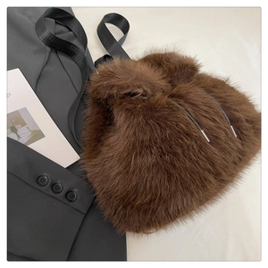 Top view of dark brown plush bucket bag with drawstring closure and black strap