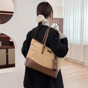 Close-up detail of vintage canvas tote bag with brown leather straps and metal buckle