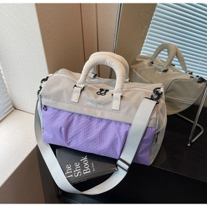 Detail of travel bag with beige and purple plaid pattern and adjustable shoulder strap