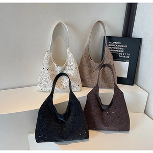 Detail of hollowed-out tote bags in four colors arranged on geometric display stands