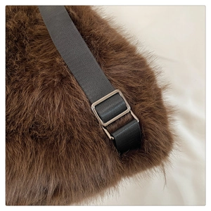 Detailed macro view of dark brown plush fabric with nylon strap and metal buckle