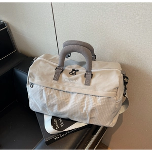 Detail of grey travel bag with quilted texture, padded handles and adjustable strap