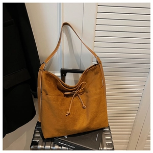 Detail of suede caramel tote bag with bow tie and adjustable metal buckle strap