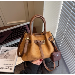 Caramel suede bucket bag detail showing premium texture and brown leather handle